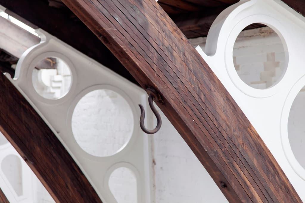German-Gymnasium-x-The-Spaces-by-Emli-Bendixen_Laminated-roof-timbers-showing-cast-iron-fillets-and-supporting-brickwork,-and-original-cast-iron-hooks