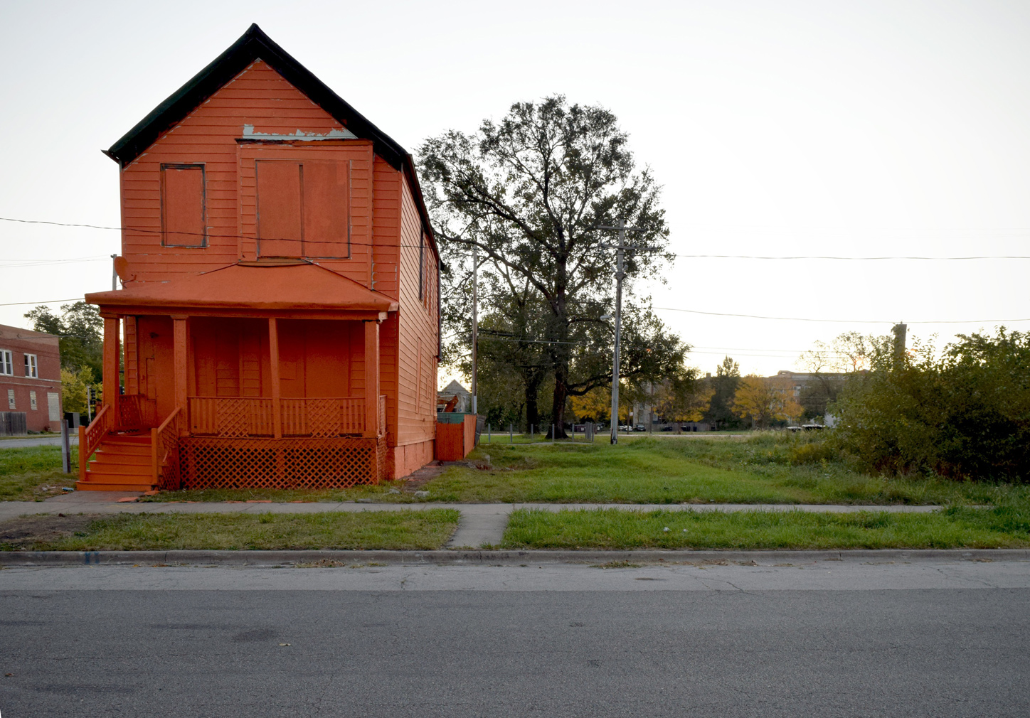 Abandoned house painted in Flamin' Hot Cheetos orange by Amanda Williams (c)