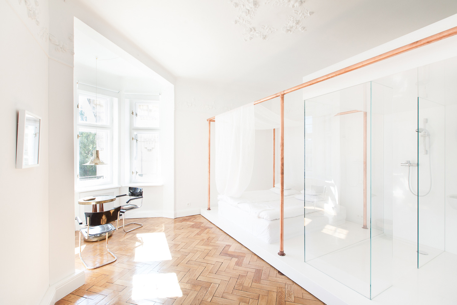 White bedroom suite with copper detailing and glass bathroom