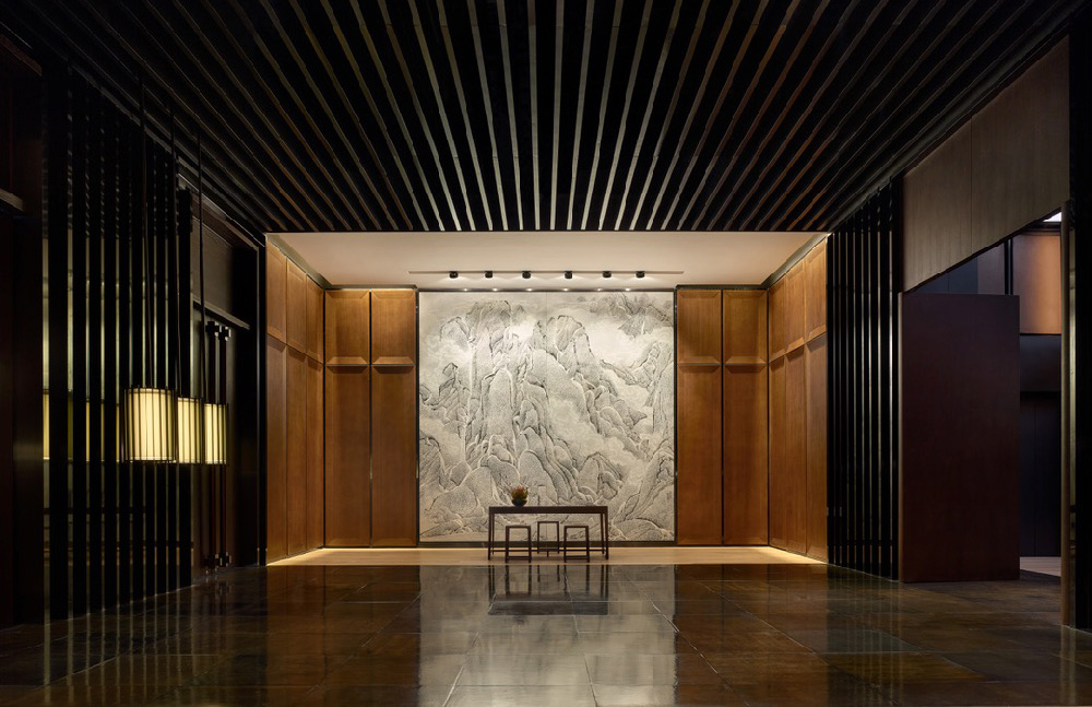 The sculptural lobby of the PuXuan Hotel and Spa which features dark and light woods, rubbed ceilings and polished stone floors