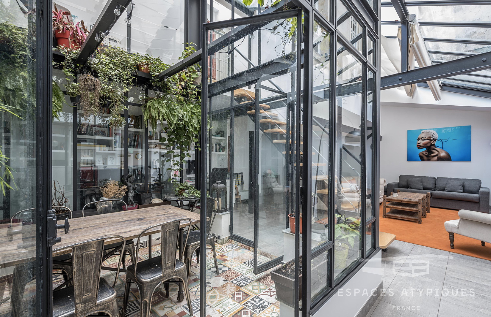 At the heart of the Paris property is a glass courtyard atrium, complete with dining table and hanging plants