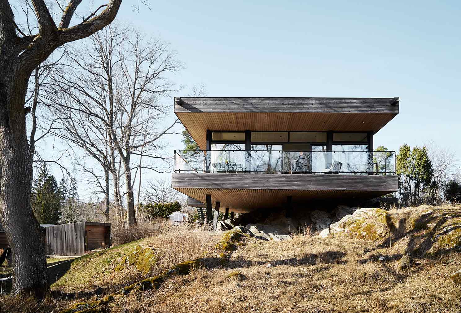 A minimalist Swedish home floats above a rocky outcrop in Värmdö 