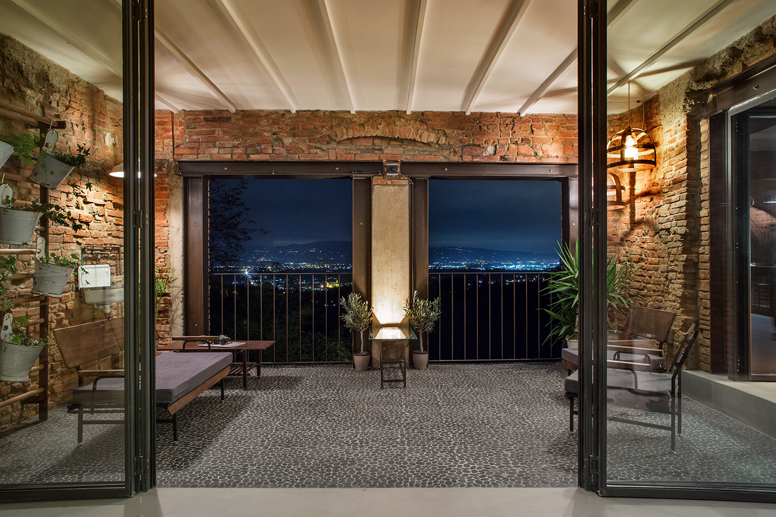 New full-height glass doors lead to a shaded balcony area with pebbled floors