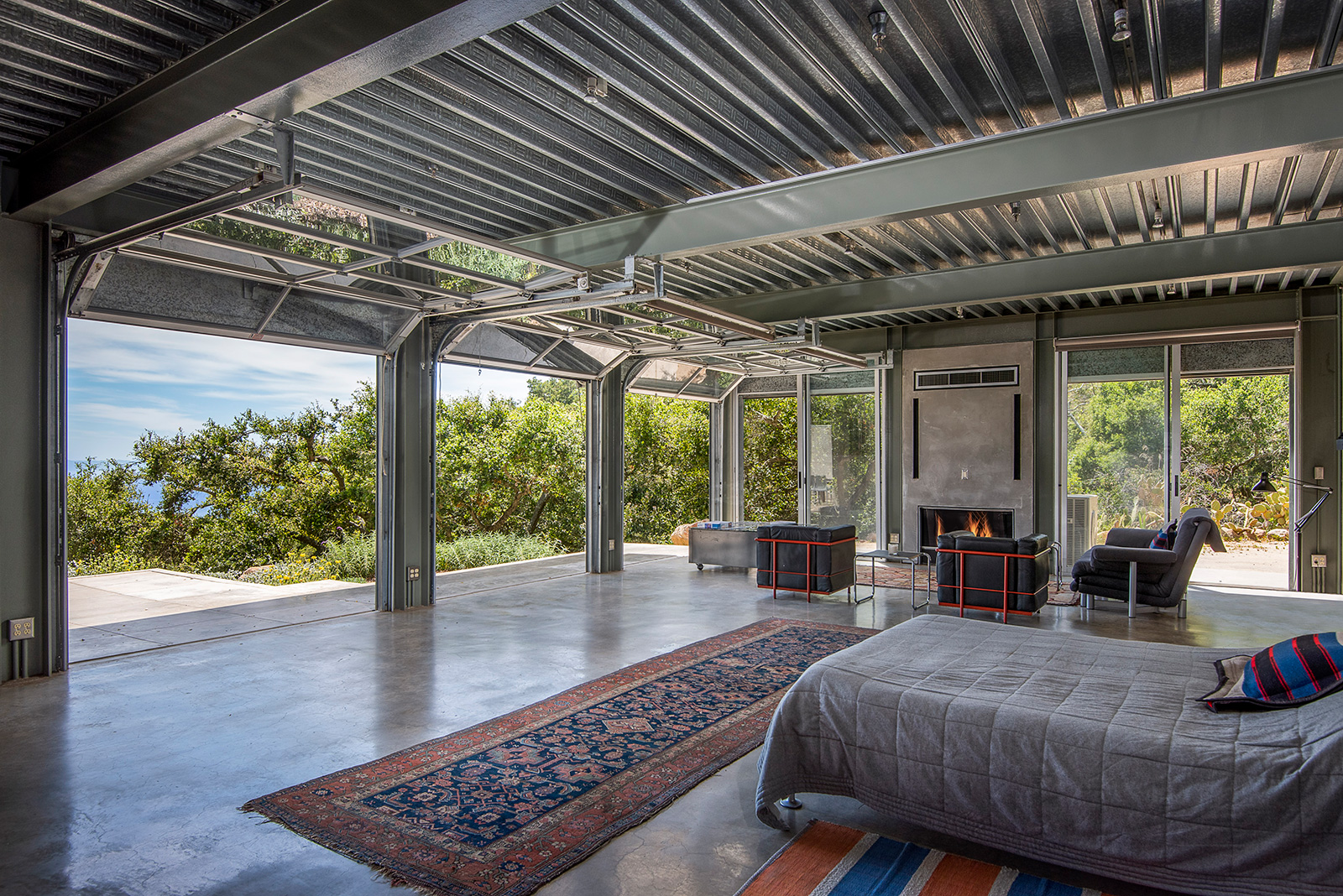 Concrete floors, steel beams, corrugated ceilings and rolling steel-framed doors feature inside the industrial style Barton Myers Residence, for sale in Santa Barbara via Sotheby's International 