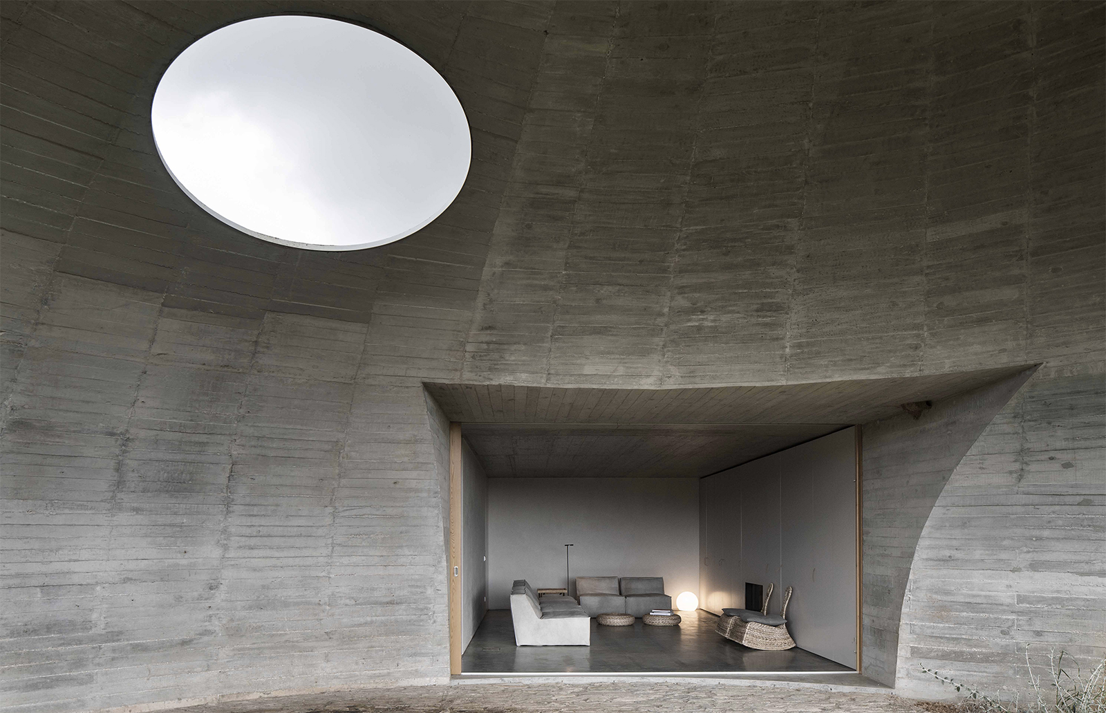 Casa na Terra or ‘House in the Earth’ is a concrete volume with geometric voids carved out of it to create monastic communal spaces and three ensuite bedrooms.