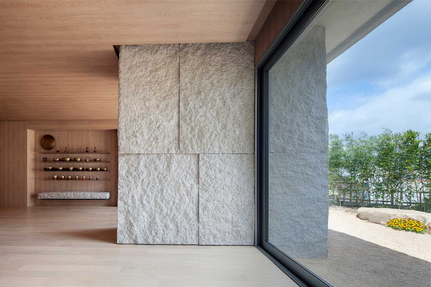 Oversized window panes overlook zen gardens in the Yoga Studio's grounds